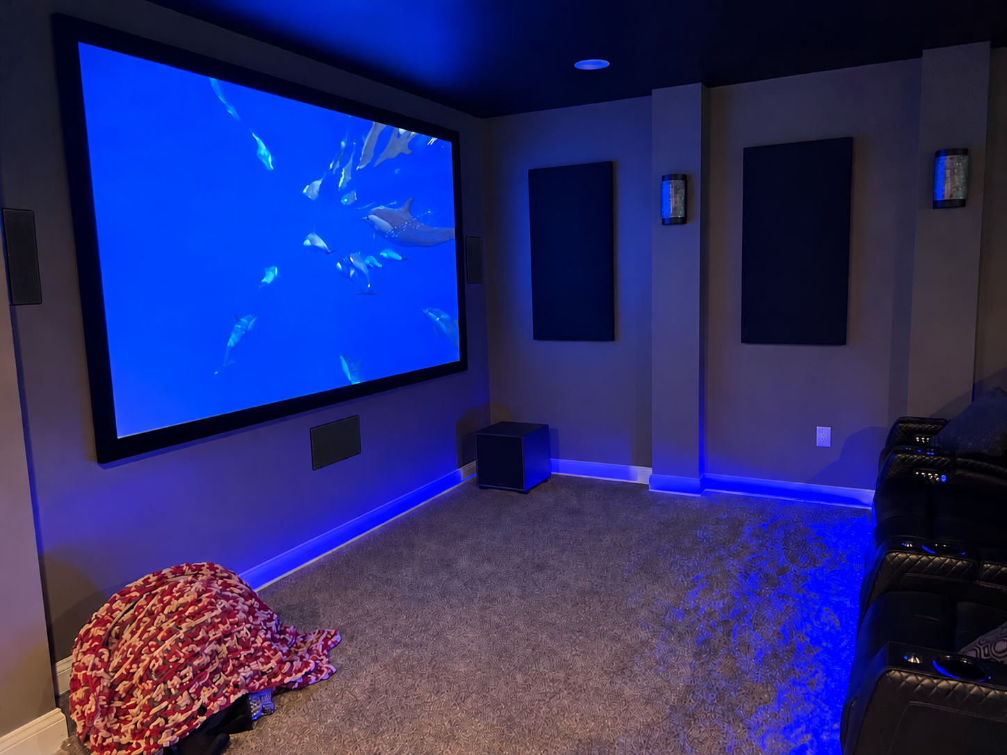 Home theater installation with projection screen and blue accent lighting